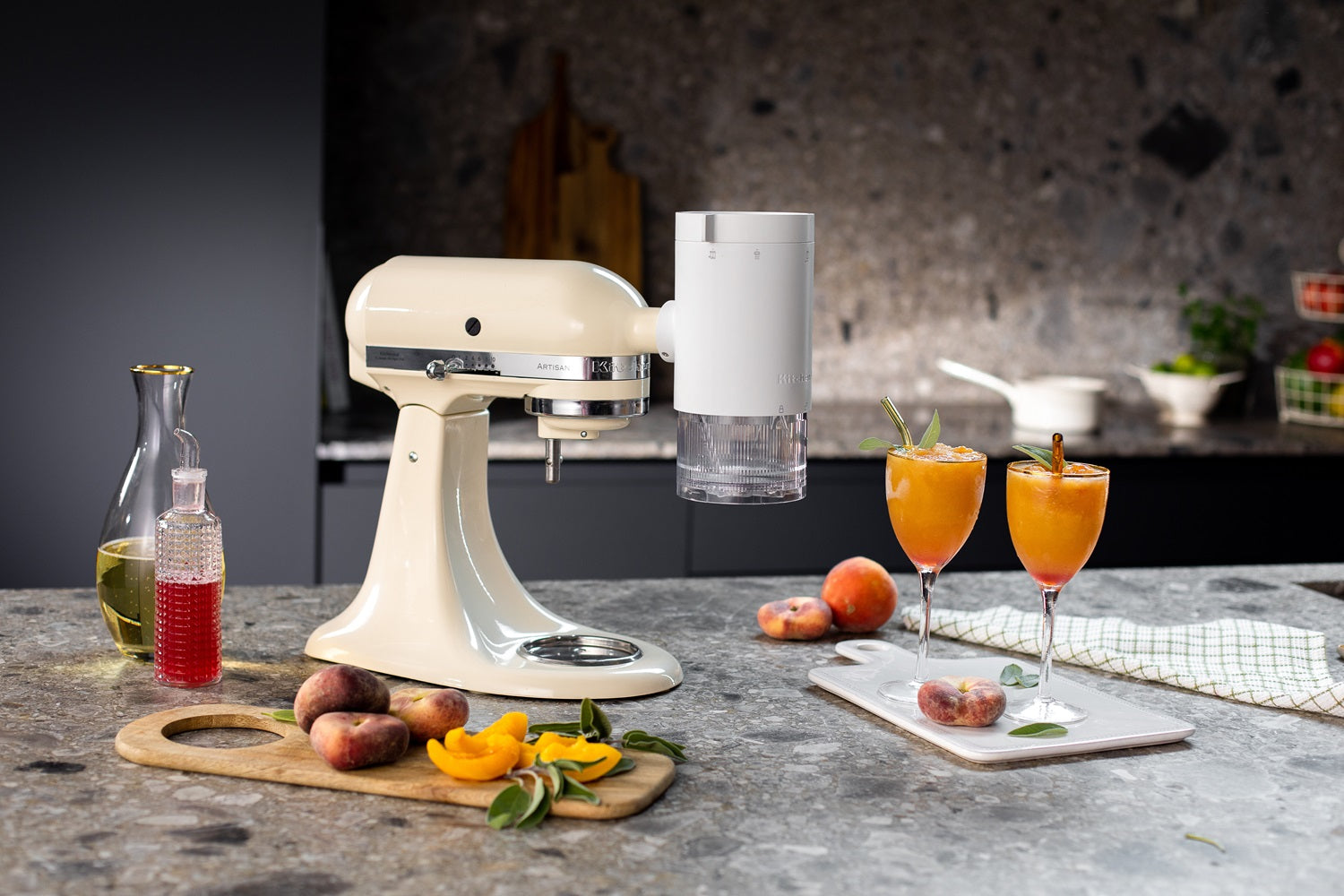 KitchenAid Küchenmaschine in creme mit aufgesetztem Shave Ice Vorsatz auf dunkler Küchenplatte