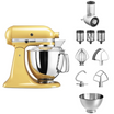 Gelbe KitchenAid Küchenmaschine mit Gemüseschneider, Zusatztrommeln, Rührelementen und kleiner Edelstahlschüssel im Set auf weißem Hintergrund