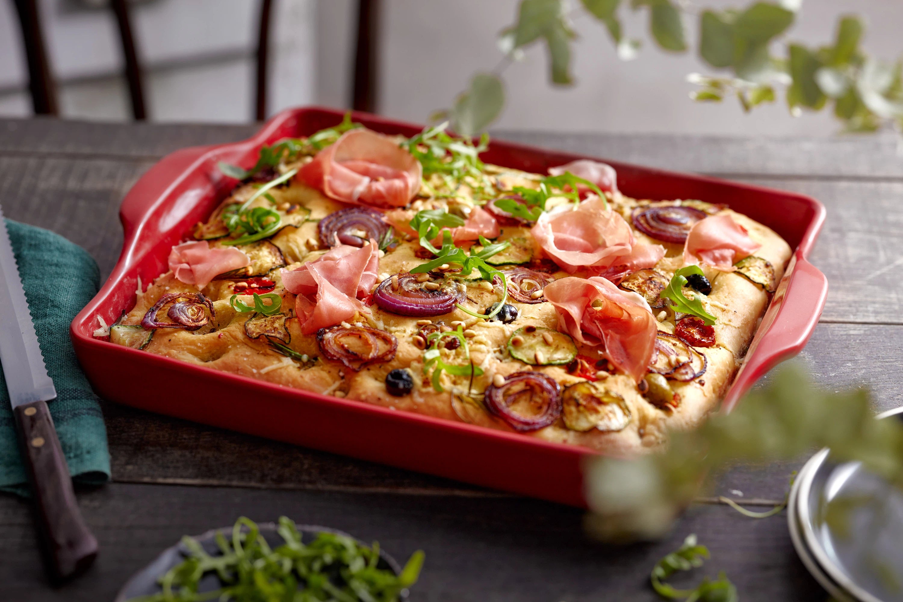 Emile Henry Keramik auf dunklem Holztisch mit Focaccia