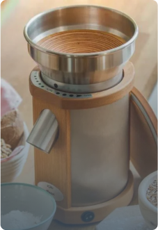 Getreidemühle mit geöffnetem Deckel auf Holzplatte