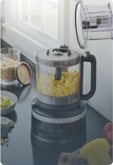 KitchenAid Food Prozessor in schwarz auf schwarzer Küchenplatte, beinhaltet Mais