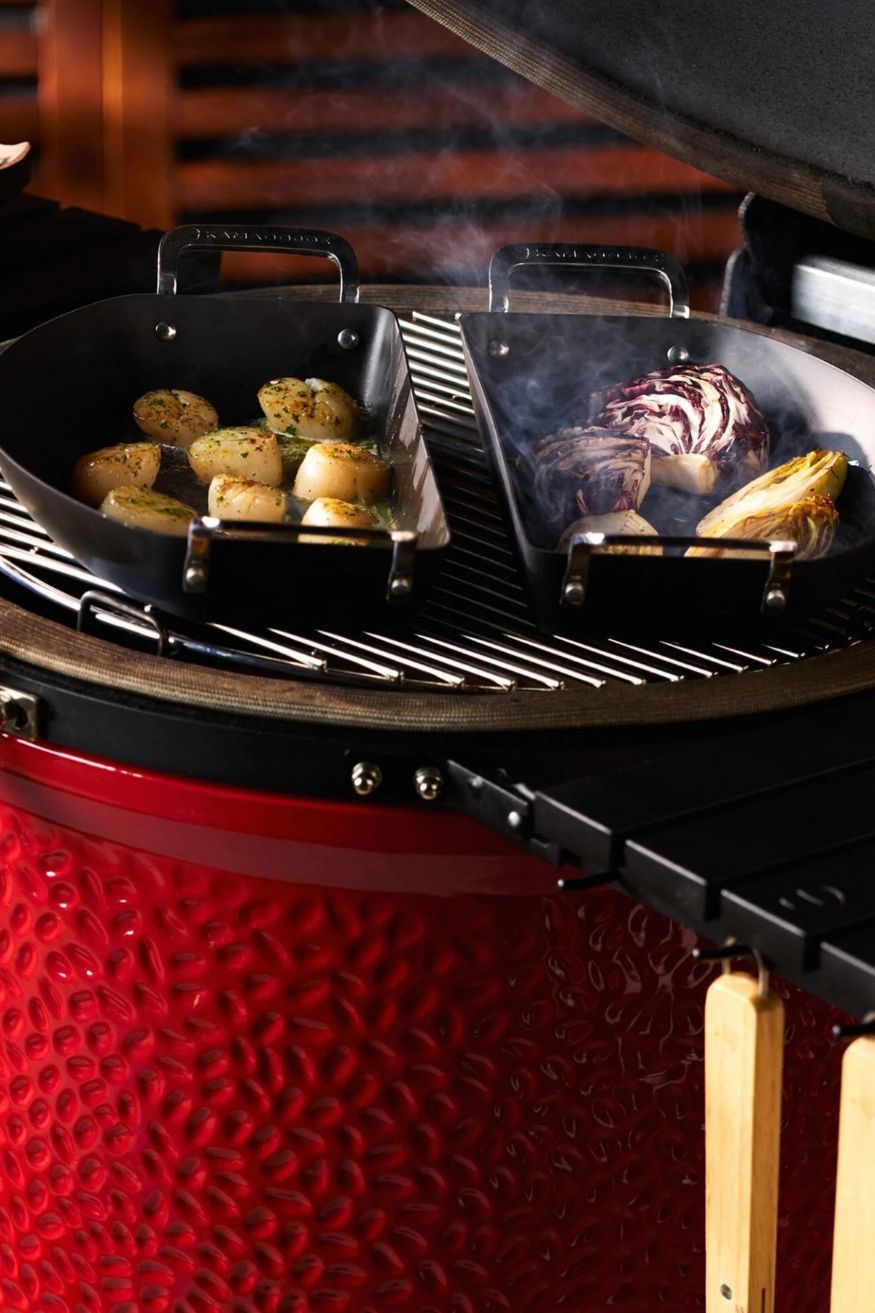 Gemüse, das auf einem roten Kamado Joe Grill gegrillt wird in Gusseisenformen