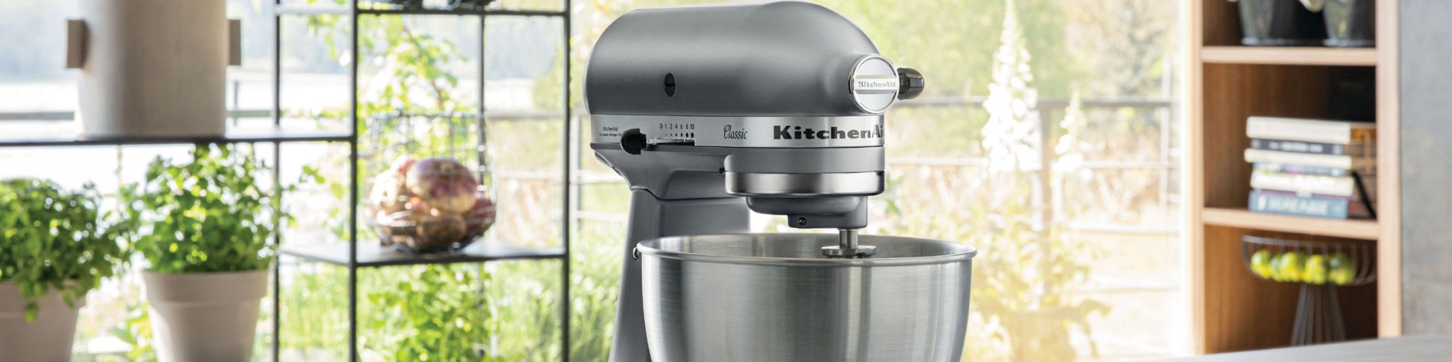 KitchenAid Classic Küchenmaschine vor großer Fensterfront im Grünen