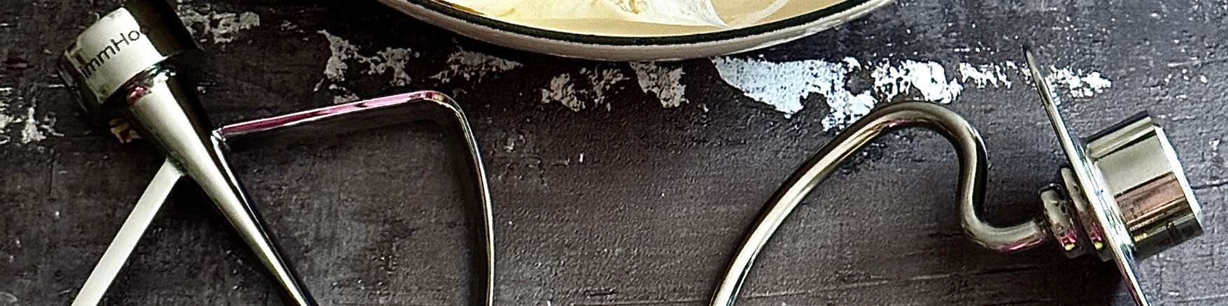 TschimmHook Flachrührer und Knethaken liegen auf dunkler, rauer, Oberfläche