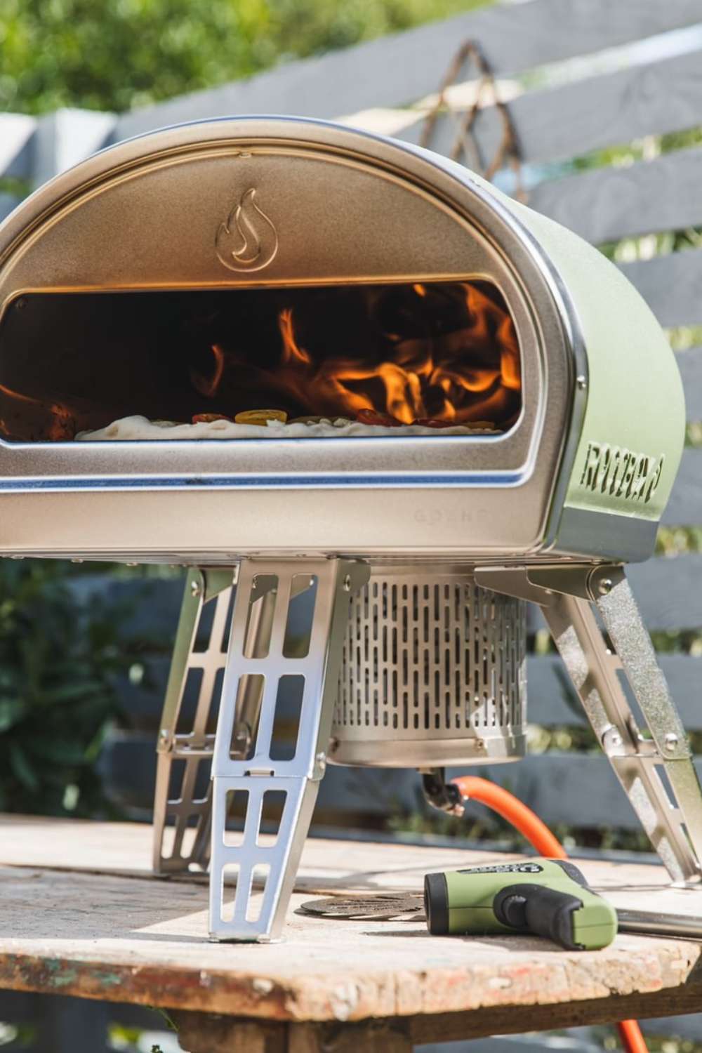 Pizzaofen im Garten stehend auf einem alten Holztisch