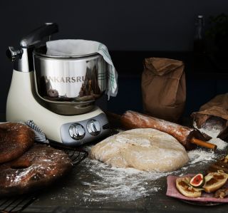 Küchenmaschine von Ankarsrum beim Brotbacken mit Mehl, Teigrolle und Broten