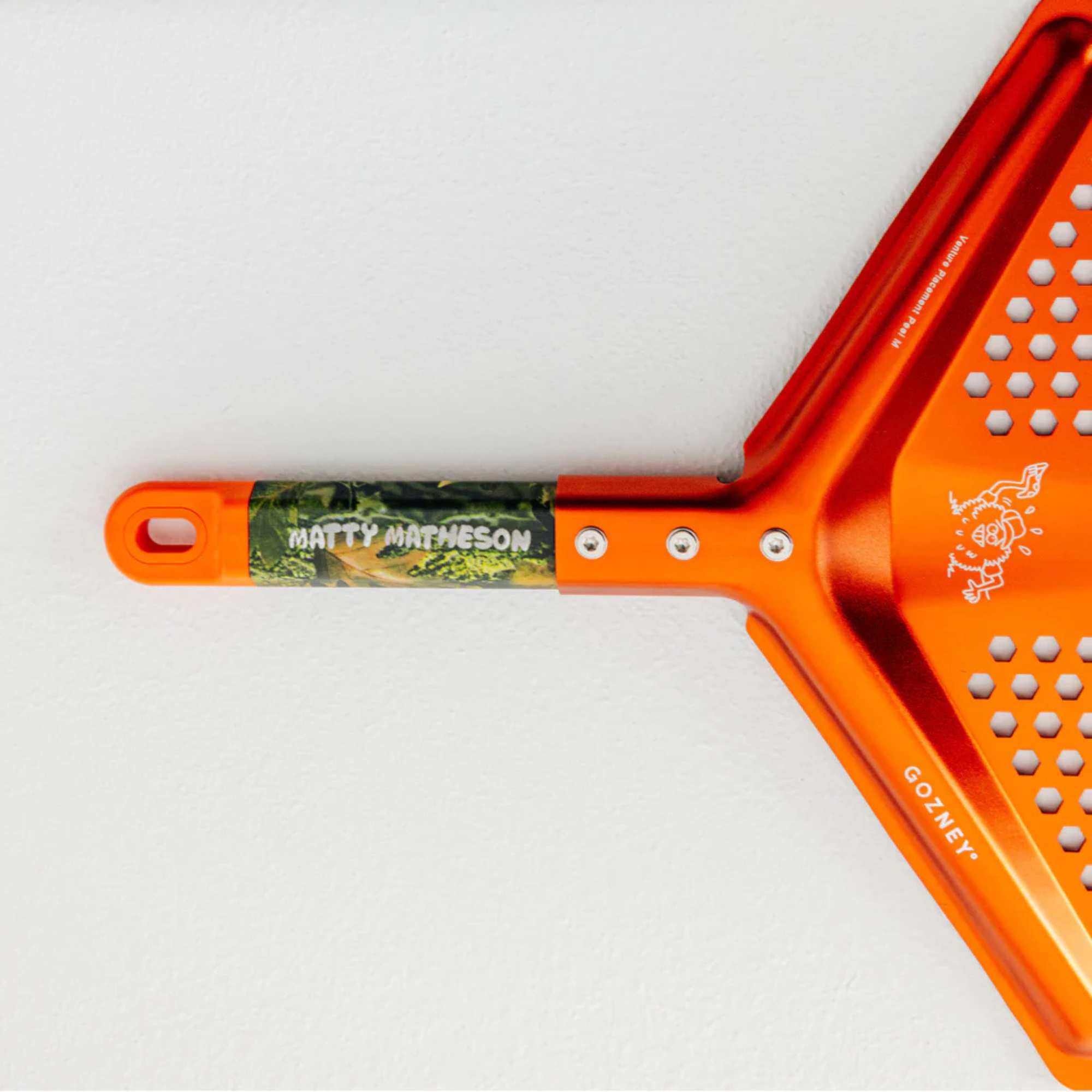 Detailaufnahme eines Pizzaschieber der Marke Ooni aus der Matty Matheson Edition in der Farbe Orange