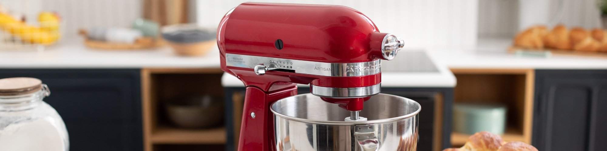 Nahaufnahme einer roten KitchenAid Kuechenmaschine wie sie vor einer Kuechenzeile steht.