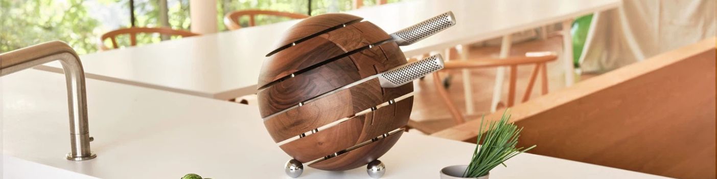 Rundes Messerblock-Set aus Holz mit mehreren Küchenmessern auf Küchenarbeitsplatte.