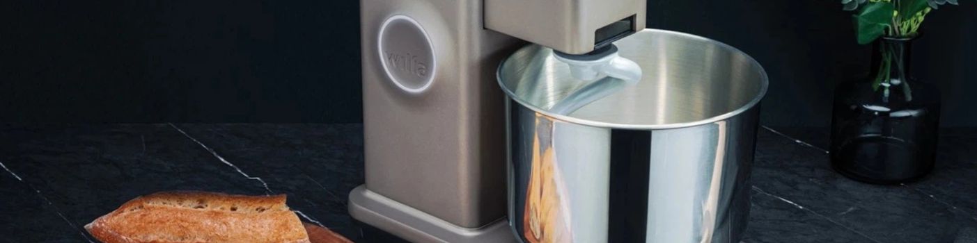 Wilfa Küchenmaschine mit Edelstahlschüssel auf Arbeitsfläche neben Brot.