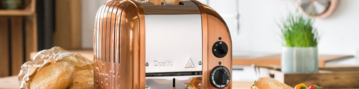 Nahaufnahme eines Dualit Classic 2-er Toaster in der Farbe Kupfer, wie er auf einem Küchenzeile neben getoasteten und belegten Bagels steht.